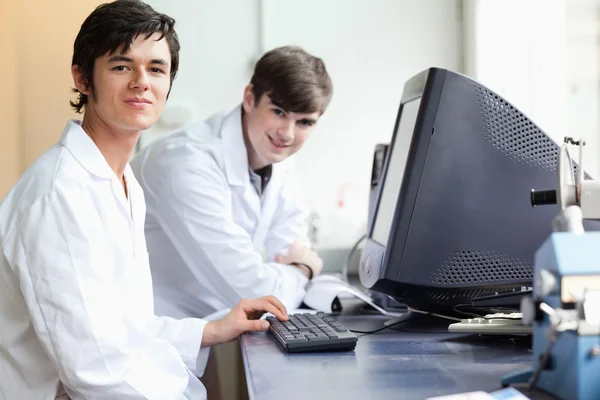 Studenten poseren met een monitor — Stockfoto