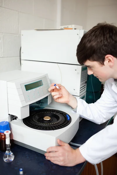 Male laboratory assistant using a centrifuge — Stock Photo, Image