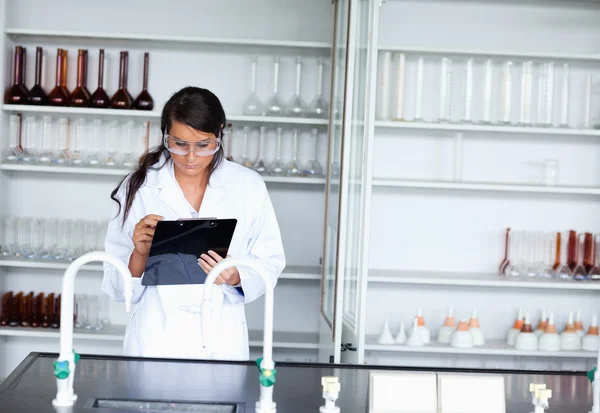 Vážné ženské vědec psaní na tabuli — Stock fotografie