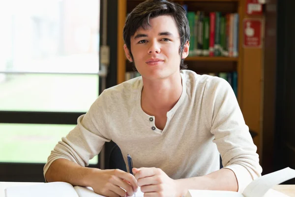 Sorridente studente maschio scrivere un saggio — Foto Stock