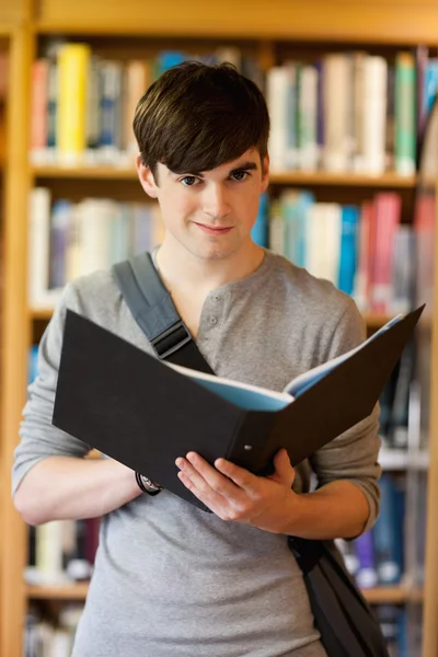 Portrait of a smiling student holding a binder — Stock Photo, Image