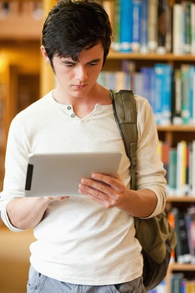 Портрет серьезного студента с помощью планшетного компьютера — стоковое фото