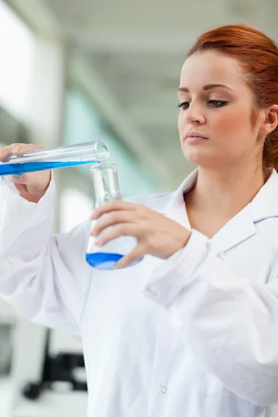 Porträt eines Wissenschaftlers, der blaue Flüssigkeit in eine Erlenmeyerfla gießt — Stockfoto