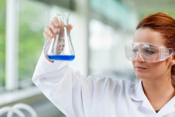 Estudante de ciências a olhar para um frasco de Erlenmeyr — Fotografia de Stock