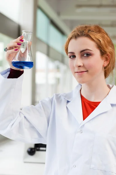 Ritratto di un chimico con un liquido blu — Foto Stock