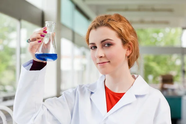 Químico segurando um líquido azul — Fotografia de Stock