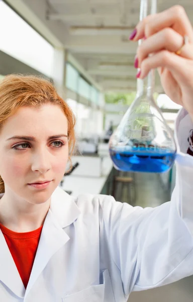 Portrét roztomilé věda student držící modrou tekutinu — Stock fotografie