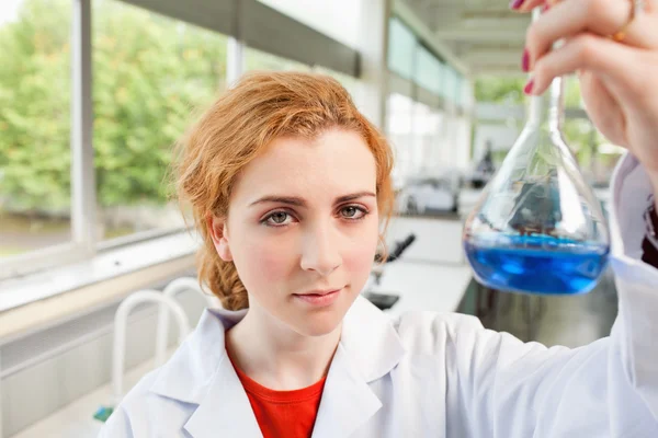 Estudante de ciências bonito segurando um frasco — Fotografia de Stock