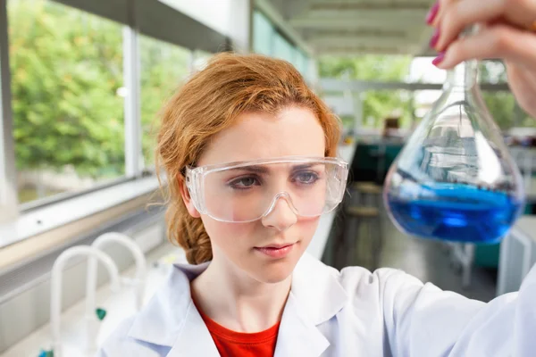 Věda student při pohledu na baňky — Stock fotografie