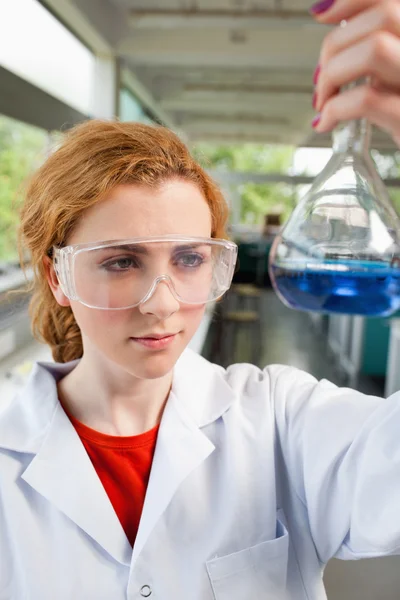 Retrato de um estudante de ciências olhando para um frasco — Fotografia de Stock
