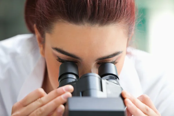 Close up of a scientist looking into a microscope — Stock Photo, Image