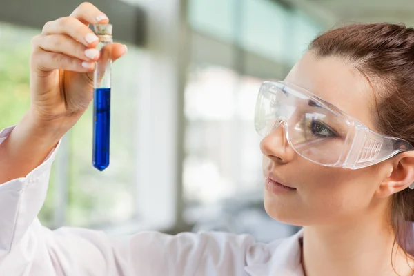Estudante de ciências feminina olhando para um tubo de teste — Fotografia de Stock