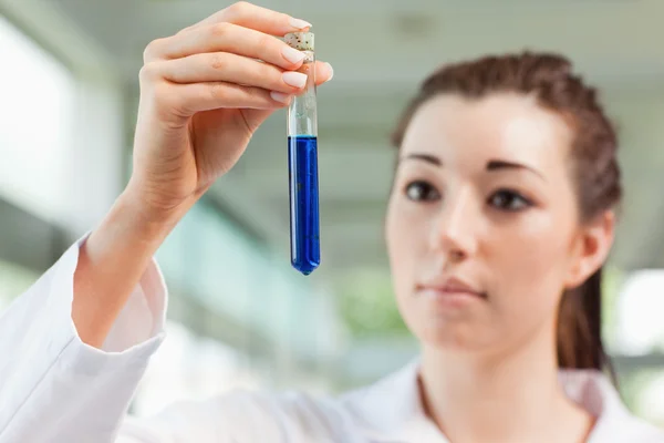 Morena cientista olhando para um tubo de ensaio — Fotografia de Stock