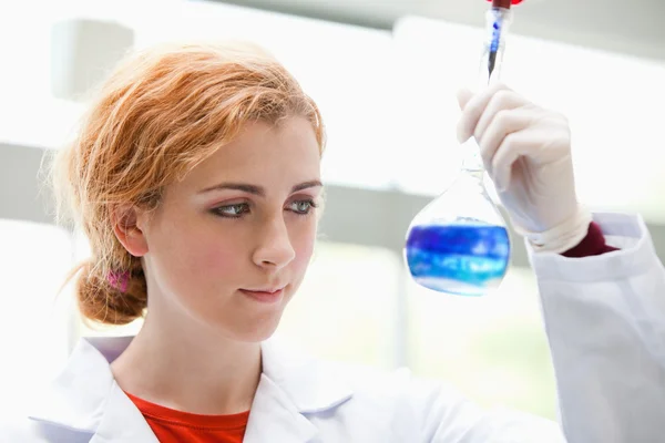 Estudante de ciências olhando para um líquido misto — Fotografia de Stock