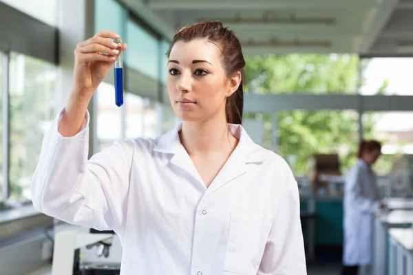 Beautiful scientist looking at a test tube — Stock Photo, Image