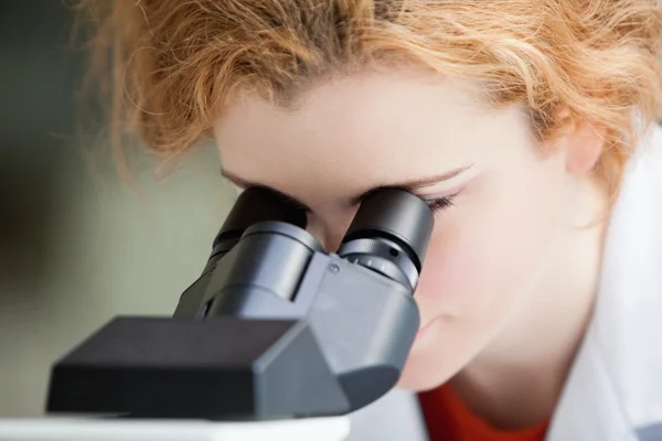Primer plano de un joven estudiante mirando al microscopio — Foto de Stock