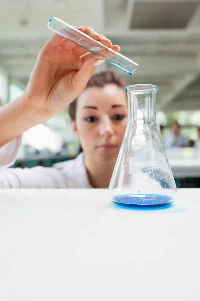 Portrait of a serious science student pouring liquid — Stock Photo, Image