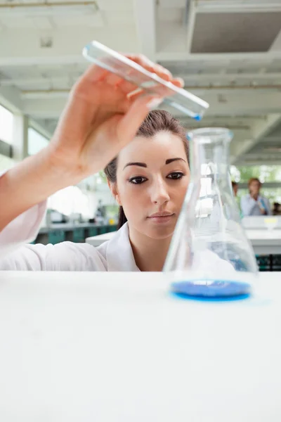 Portrait of a focused science student pouring liquid — Stock Photo, Image