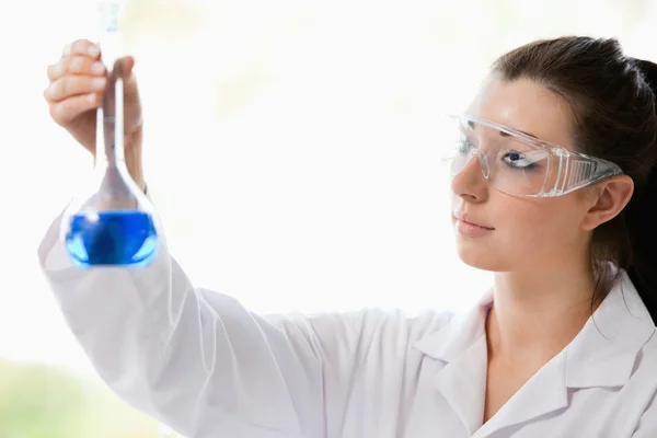 Hermoso científico mirando un frasco — Foto de Stock