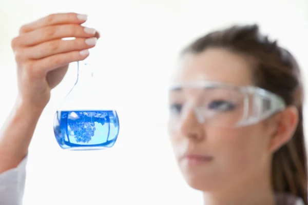 Close up of a scientist looking at flask — Stok fotoğraf
