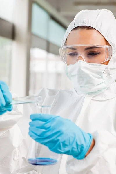Portrait of a protected female scientist pouring liquid — Stock Photo, Image