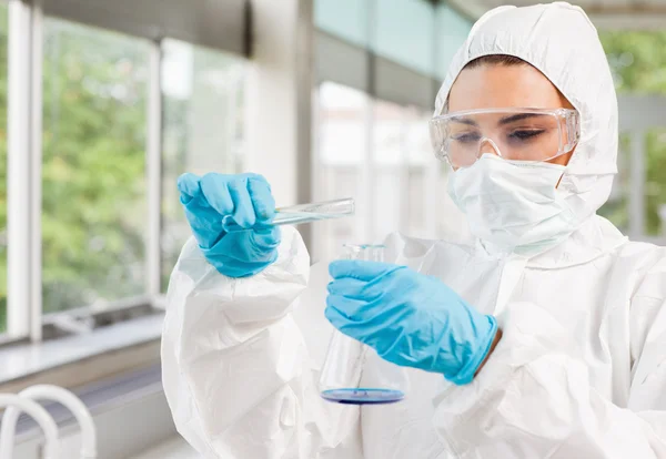 Protected scientist pouring liquid — Stock Photo, Image