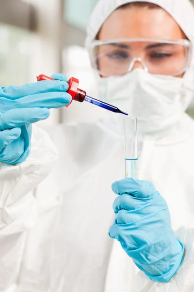 Retrato de um cientista protegido soltando um líquido em um teste tu — Fotografia de Stock