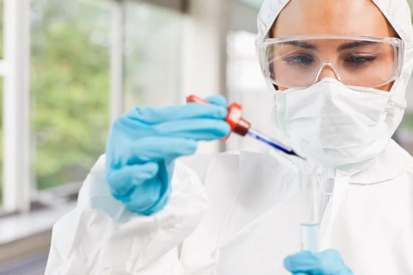 Protected science student dropping a liquid in a test tube — Stock Photo, Image