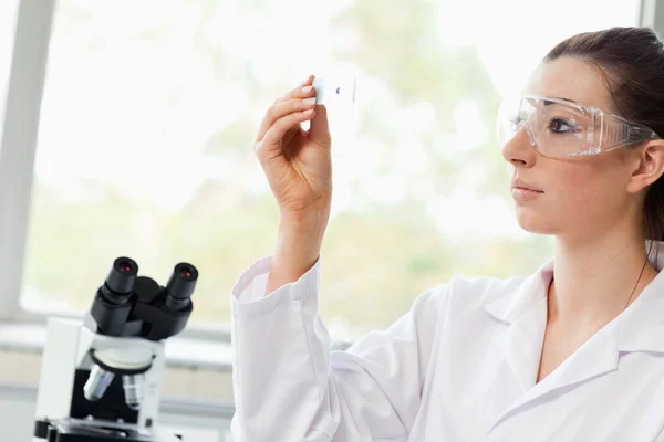 Beautiful science student looking at a microscope slide — Stock Photo, Image