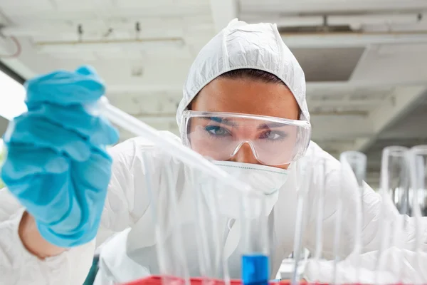 Close up of a protected science student dropping liquid in a tes — Stock Photo, Image