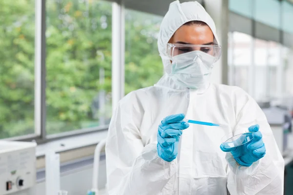 Protected science student dropping blue liquid in a Petri dish — Stock Photo, Image