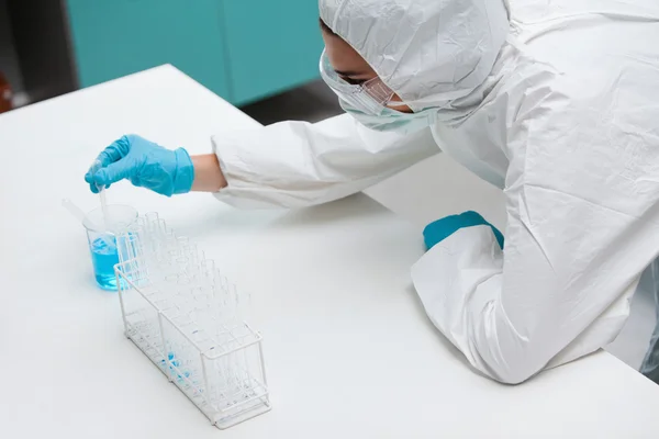 Protected science student pumping liquid with a pipette — Stock Photo, Image