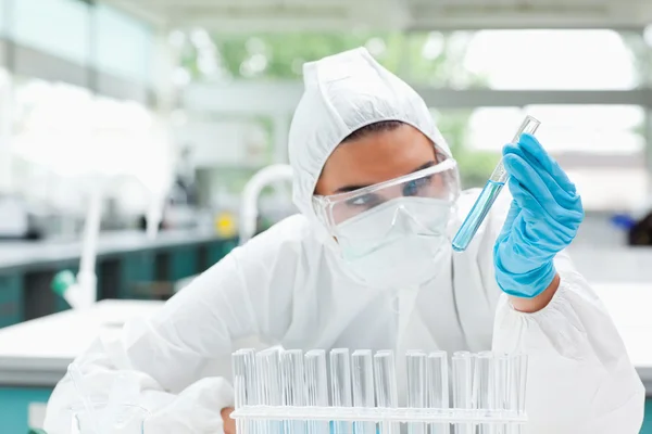 Protected scientist looking at a test tube — Stock Photo, Image