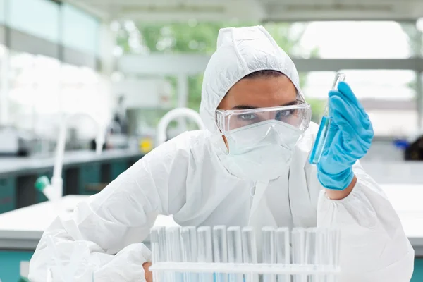 Protected female scientist holding a test tube — Stock Photo, Image