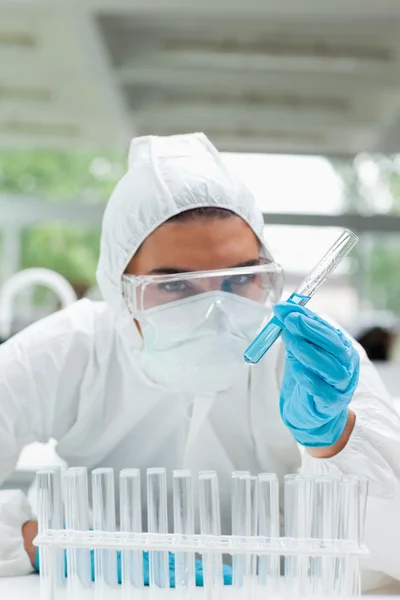 Portrait of a protected serious scientist holding a test tube — Stock Photo, Image