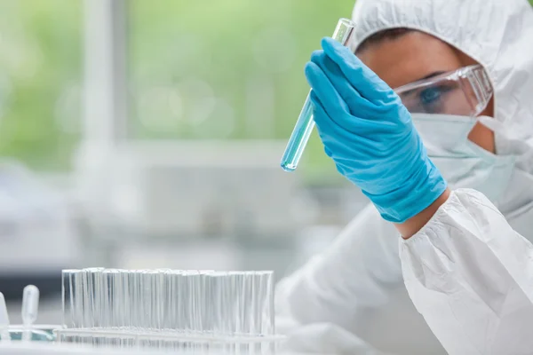 Protected science student looking at a test tube — Stock Photo, Image
