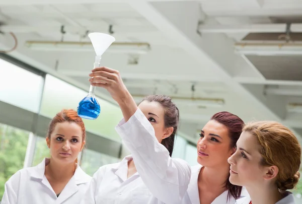Estudantes de ciências a olhar para um frasco — Fotografia de Stock