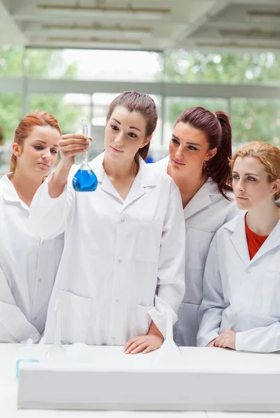 Portrait of science students looking at a flask — Stock Photo, Image