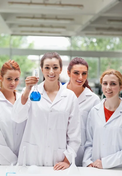 Retrato de parceiros de laboratório posando com um frasco — Fotografia de Stock