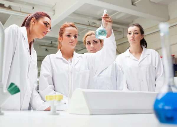 Chemistry students looking at a liquid — Stock Photo, Image