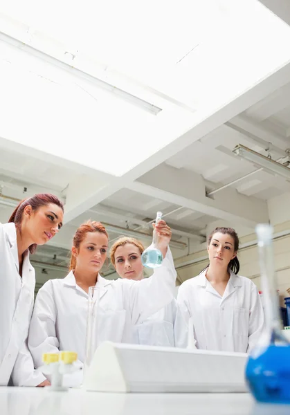 Cute chemistry students looking at a fkask — Stock Photo, Image