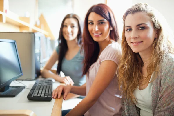 Studiekamrater som poserar med en dator — Stockfoto
