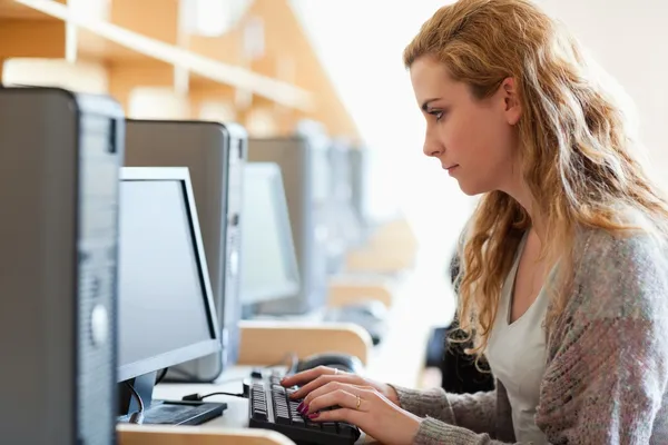 Симпатичный студент, работающий с компьютером — стоковое фото