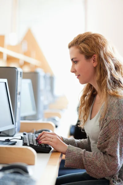 Retrato de um estudante bonito que trabalha com um computador — Fotografia de Stock