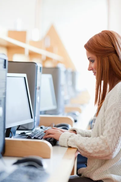 Porträt einer jungen Studentin, die mit einem Computer arbeitet — Stockfoto