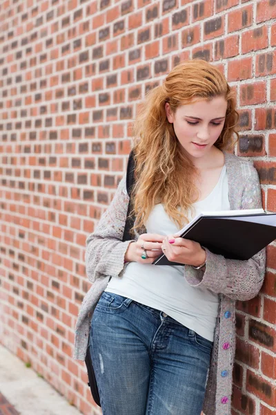 Porträtt av en härlig student läsa hennes anteckningar — Stockfoto