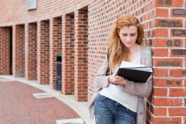 그녀의 노트를 읽는 젊은 학생 — 스톡 사진
