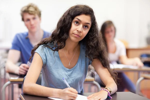 Konzentrierte Schülerin macht sich Notizen — Stockfoto