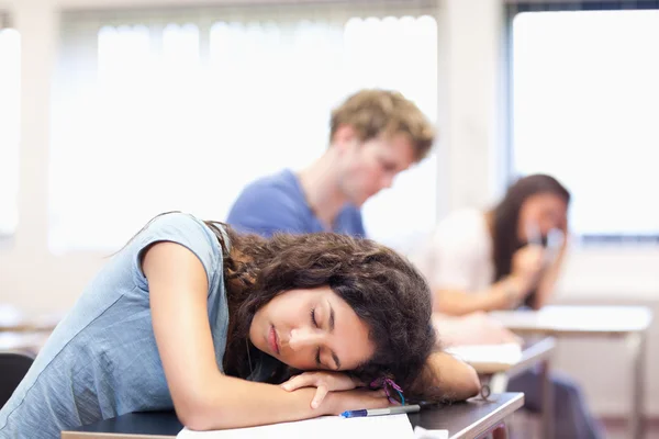 Studentin schläft auf ihrem Schreibtisch — Stockfoto