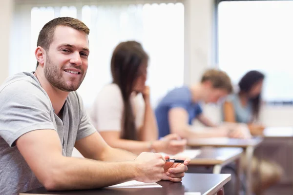 Smiling young man sitting — Stock Photo, Image